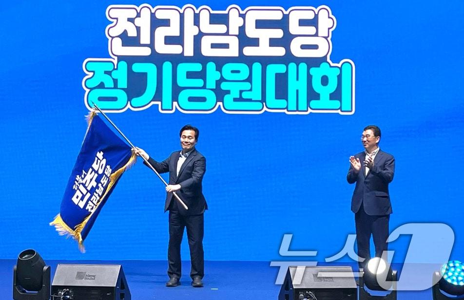 본문 이미지 - 더불어민주당 전남도당위원장에 선출된 주철현 의원이 4일 당선 확정 후 전남도당 깃발을 흔들고 있다..(민주당 전남도당 제공2024.8.4/뉴스1 