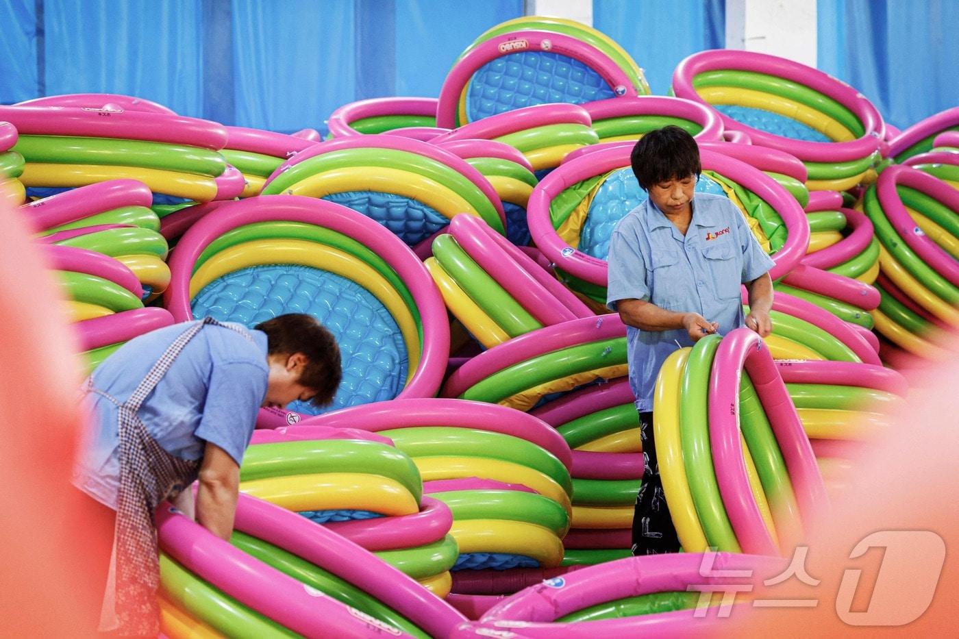 본문 이미지 - 중국 동부 장쑤성 쑤첸시의 한 공장에서 3일 직원들이 수출용 팽창식 수영 물품을 만들고 있다. 2024.08.03. ⓒ AFP=뉴스1 