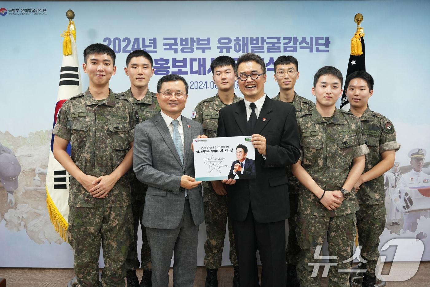 본문 이미지 - 이근원 국방부유해발굴감식단장이 5일 서울 용산구 국방부에서 '큰별쌤'으로 유명한 최태성 역사 커뮤니케이터에게 국방부 유해발굴감식단 홍보대사 위촉장을 수여한 후 장병들과 기념촬영을 하고 있다. 국유단 홍보대사는 주요 행사 참여, 초상권 사용 등 재능기부로 6·25전쟁 전사자 유해발굴사업 정책홍보에 동참한다. (국방부 제공) 2024.8.5/뉴스1