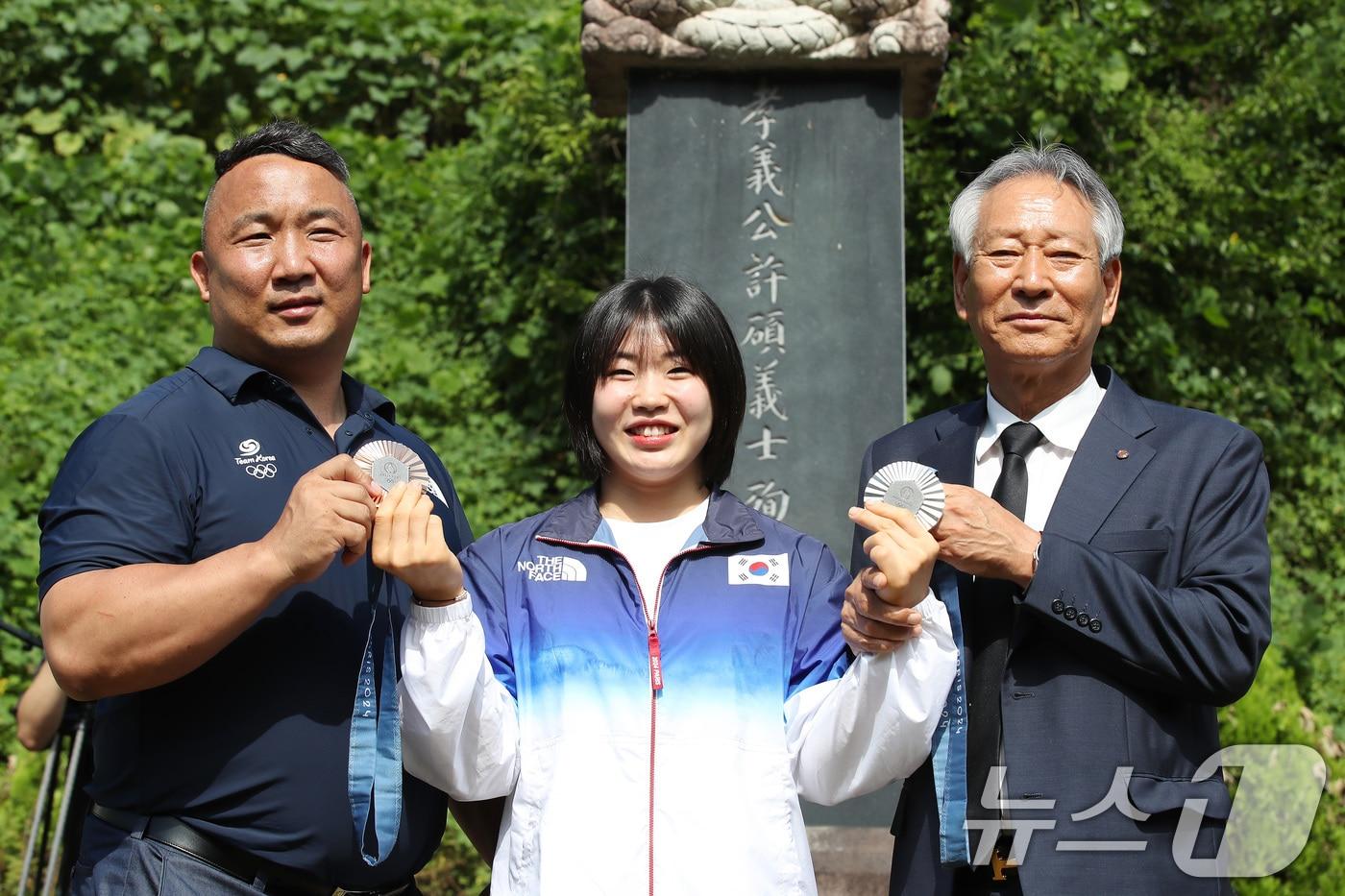 2024 파리 올림픽에서 개인전 은메달과 단체전 동메달을 딴 유도 대표팀 허미미(가운데·경북체육회)가 6일 오전 대구 군위군 삼국유사면 화수리에 마련된 독립운동가이자 현조부인 허석 지사의 추모기적비를 찾아 참배를 앞두고 메달을 들어 보이고 있다. 왼쪽부터 경북체육회 김정훈 감독, 허미미, 김점두 경북체육회장. 2024.8.6/뉴스1 ⓒ News1 공정식 기자