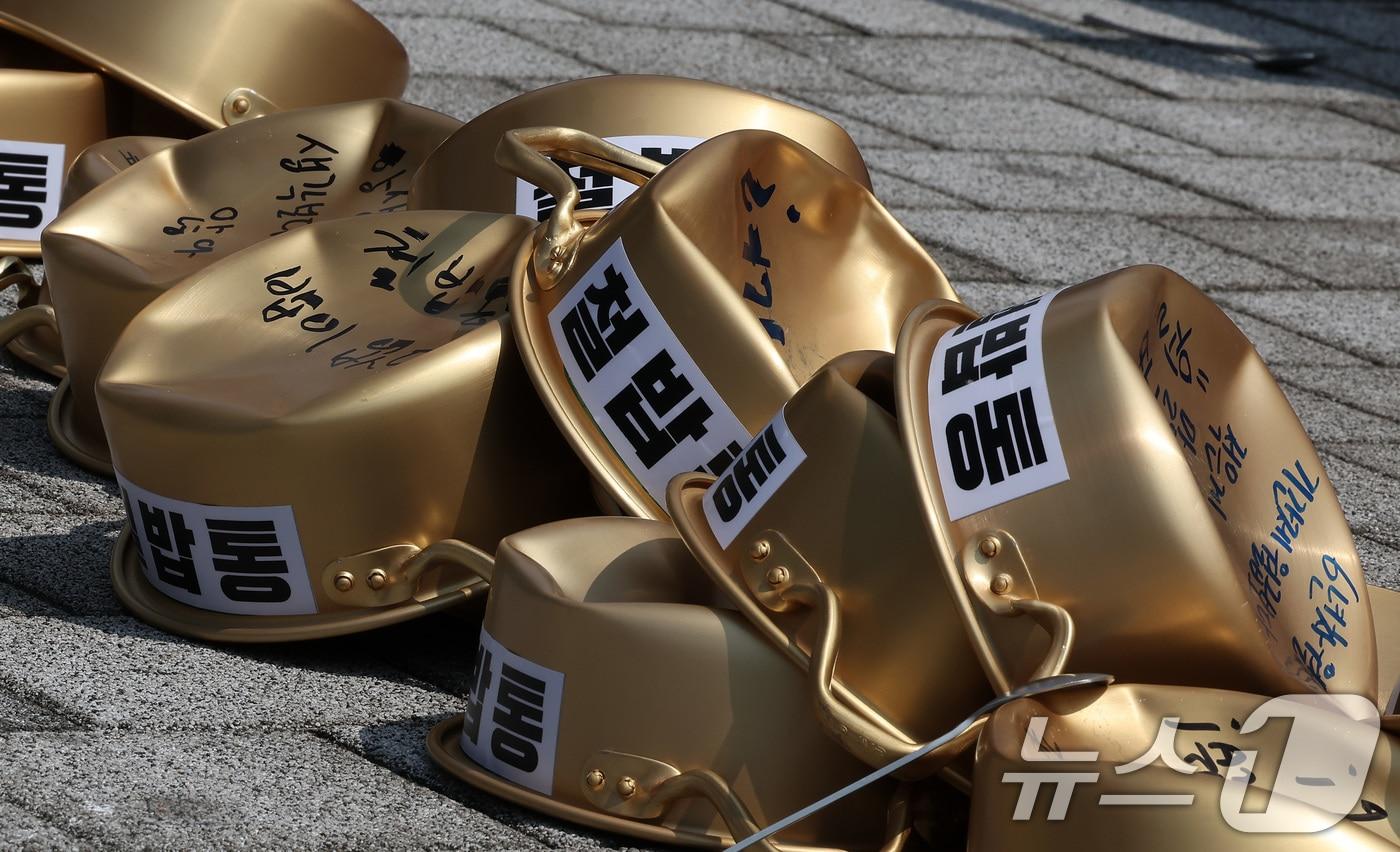 6일 서울 용산구 대통령실 앞에서 열린 임금 수당 현실화 2024년 청년공무원 100인 기자회견에서 전국공무원노동조합 2030청년위원회 회원들이 밟은 양은냄비가 놓여져 있다. 2024.8.6/뉴스1 ⓒ News1 김성진 기자