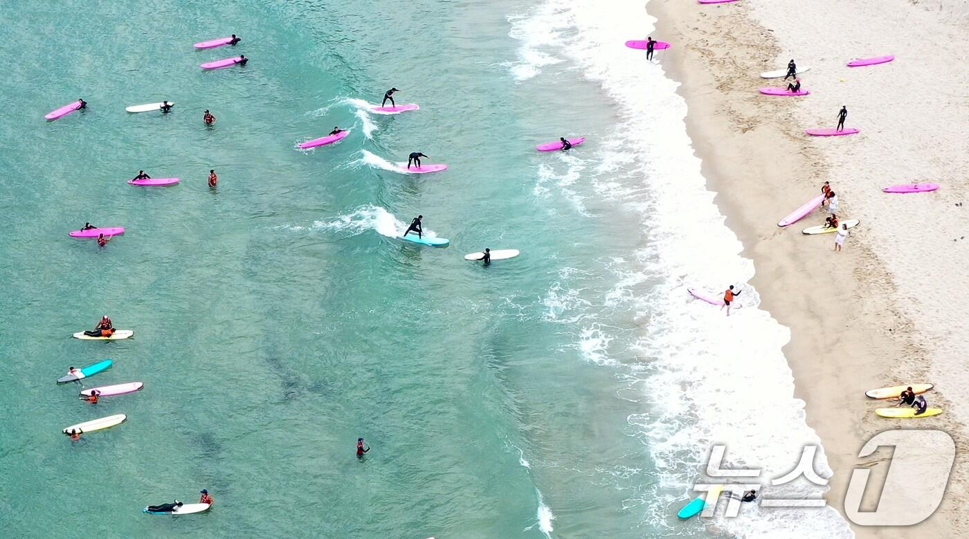 절기상 입추(立秋)를 하루 앞두고 폭염이 이어지고 있는 6일 강원 양양군 현남면 인구 해수욕장을 찾은 시민들이 서핑을 즐기고 있다. 2024.8.6/뉴스1 ⓒ News1 김진환 기자