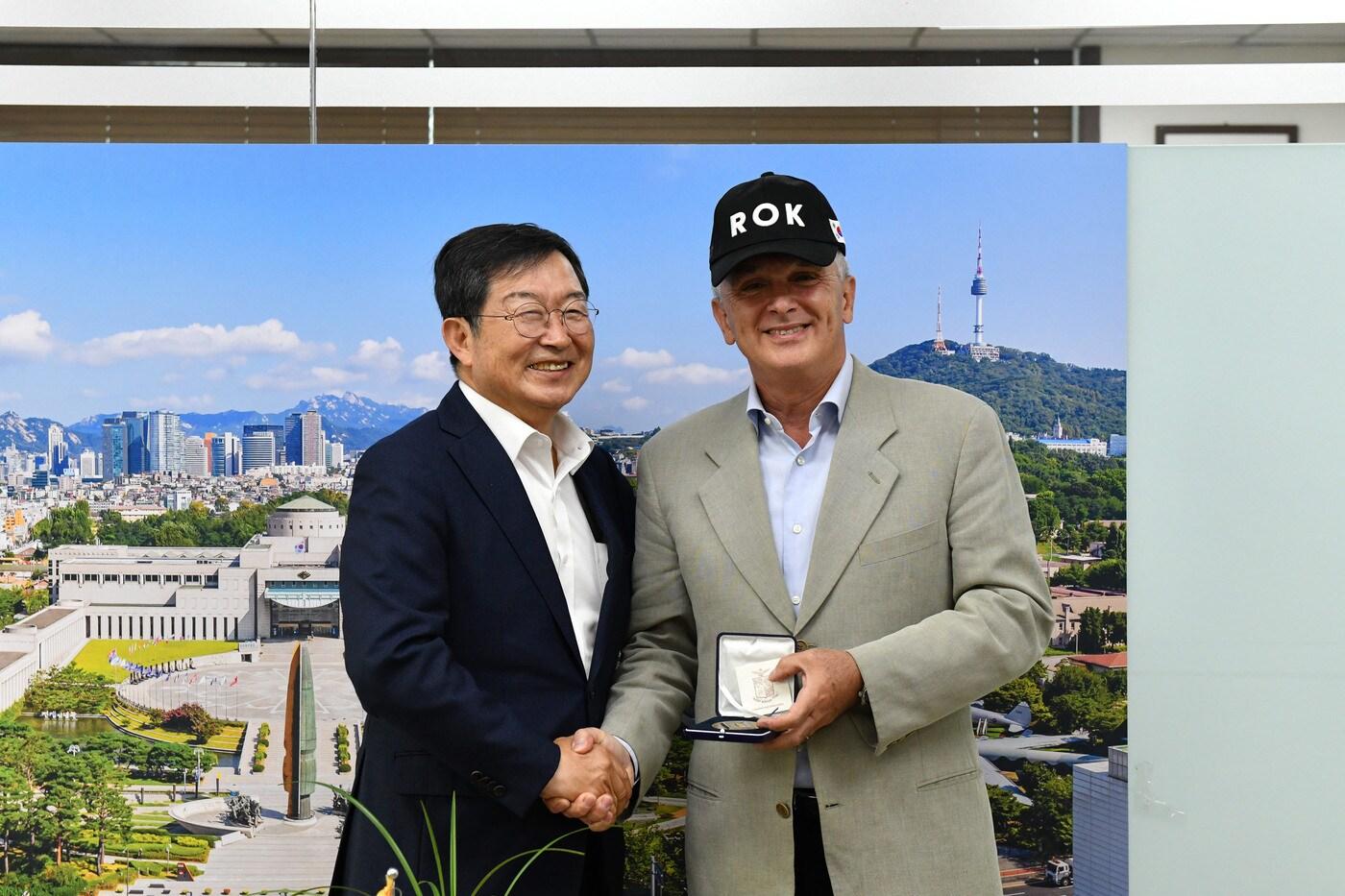 본문 이미지 - 백승주 전쟁기념사업회장과 알베르토 비아바티 이탈리아 공군작전사령관이 기념코인을 들고 기념촬영하고 있다.(전쟁기념사업회 제공)