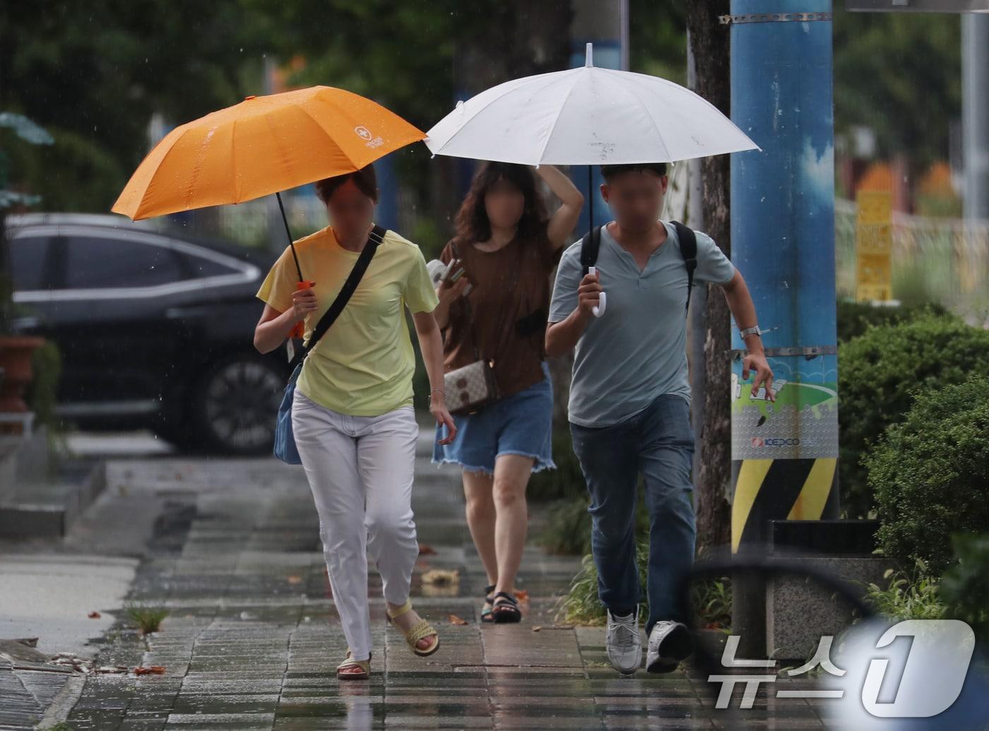 본문 이미지 - 부산 강서구청 인근에서 우산을 쓴 시민들이 갑자기 내리는 소나기를 피하며 이동하고 있다. 2024.8.6/뉴스1 ⓒ News1 윤일지 기자