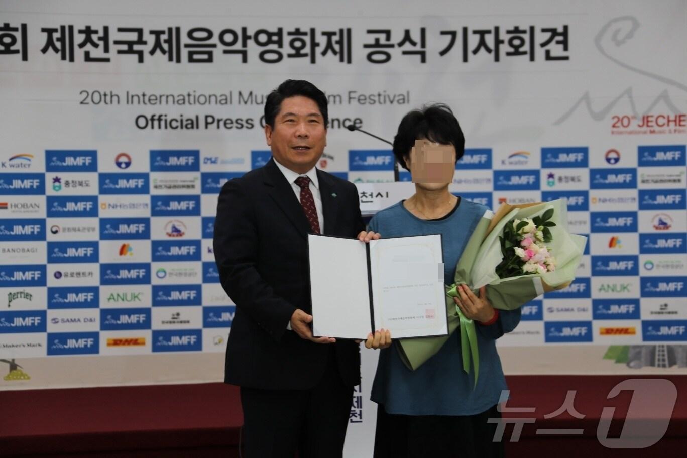 본문 이미지 - 김창규 제천시장과 홍보대사 위촉장을 받은 시민 A 씨.(제천시 제공)2024.8.7/뉴스1