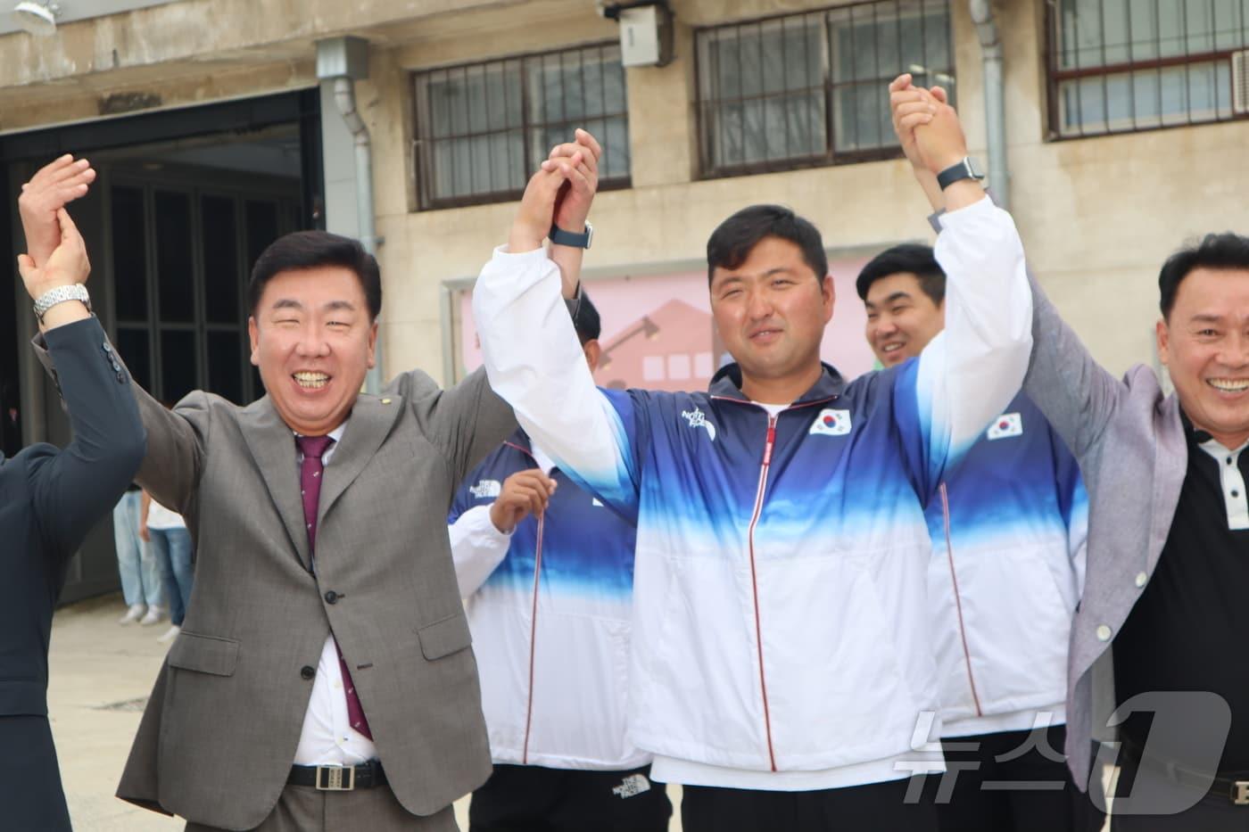 본문 이미지 - 2024 파리올림픽 남자 양궁 3관왕에 오른 김우진 선수가 8일 청주시 청원구 동부창고에서 열린 양궁선수단 환영식에 참석한 이범석 청주시장과 함께 환호하고 있다.2024.08.08.ⓒ 뉴스1 박건영 기자 ⓒ News1 박건영 기자