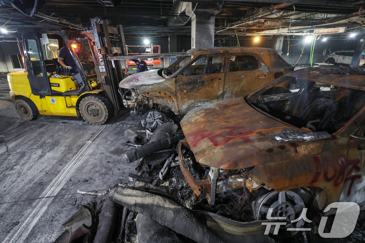 8일 인천 서구 청라동의 한 아파트단지 지하주차장에서 8월1일 발생한 전기차 화재 사고로 인해 불에 탄 차량을 지게차가 들어올리고 있다. 2024.8.8/뉴스1 ⓒ News1 민경석 기자