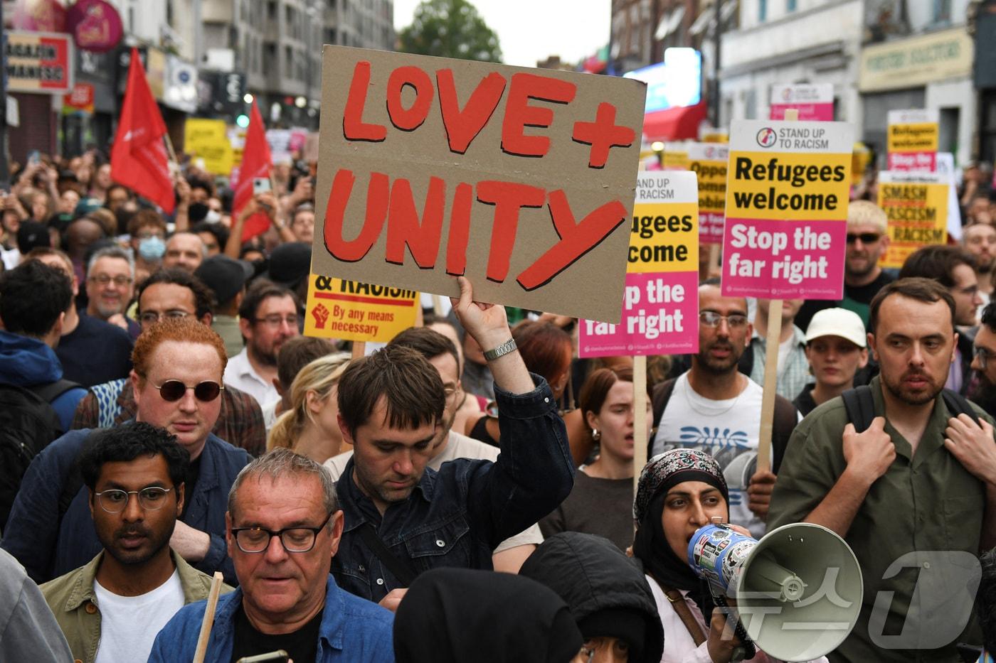 7일(현지시간) 영국 런던에서 시민들이 '난민을 환영한다' '극우를 멈추자' '공동체를 사랑하자'는 팻말을 걸고 최근 전국에서 벌어진 반(反)이민 폭동을 중단할 것을 촉구하고 있다. 2024.08.07. ⓒ 로이터=뉴스1 ⓒ News1 김성식 기자