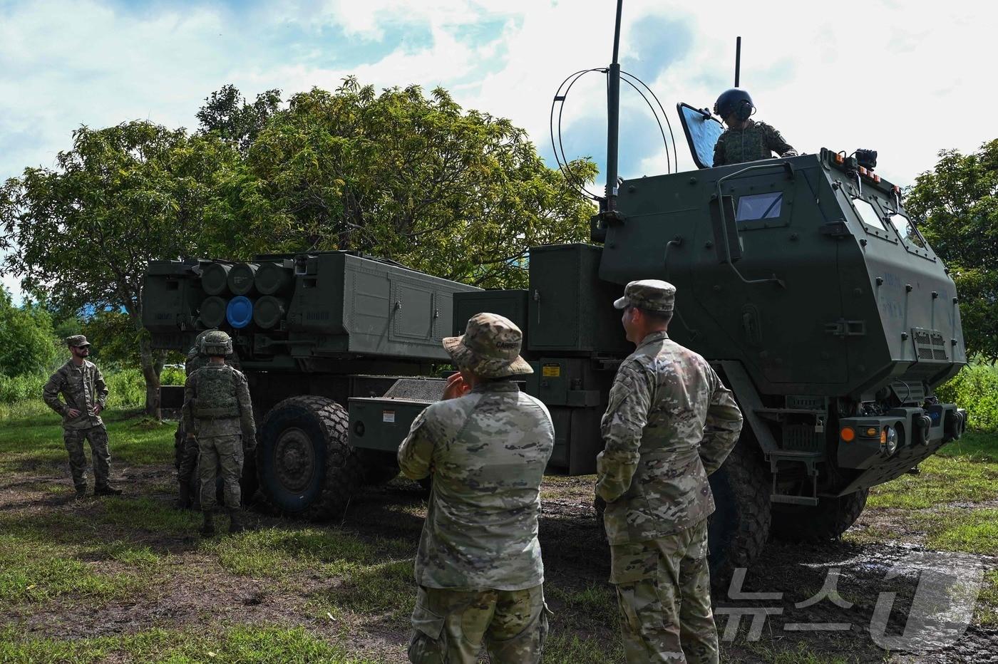 미군 병사들이 9일 필리핀 중부 라우르에서 진행된 양국 합동 군사훈련에서 필리핀 군인들이 '고기동성 포병 로켓 시스템(하이마스)'을 운용하는 것을 지켜보고 있다. 하이마스는 우크라이나 전쟁에서 정밀성과 기동성을 입증한 다연장로켓포로 227mm 로켓 6발을 장착한다. (사진은 기사 내용과 무관함) / 뉴스1 ⓒ News1 2024.08.09 ⓒ AFP=뉴스1 ⓒ News1 정지윤기자
