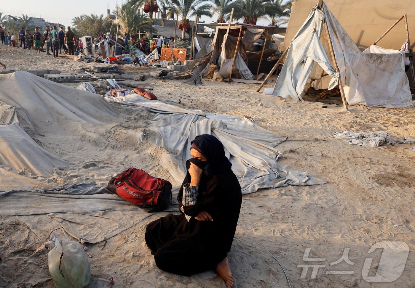 본문 이미지 - 10일(현지시간) 이스라엘군이 하마스 소탕을 명분으로 가자지구 남부 칸유니스의 난민촌을 공습해 60여명의 사상자를 냈다. 사진은 이스라엘 공습에 의해 파괴된 난민촌에 앉아 눈물을 흘리는 여성의 모습. 2024.9.10 ⓒ 로이터=뉴스1 ⓒ News1 윤주현 기자