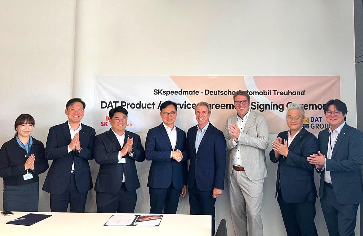 본문 이미지 - SK스피드메이트와 DAT의 AI 차량 견적 프로그램 사용 계약 체결식에 참석한 안무인 SK스피드메이트 대표와 헬머트 아이퍼트 DAT CEO를 비롯한 양사 관계자들 모습(SK스피드메이트 제공)