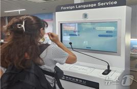 본문 이미지 - 부산도시철도 1호선 부산역을 방문한 외국인이 ‘비대면 동시통역 시스템’을 사용해 길을 물어보고 있다.(공사 제공)