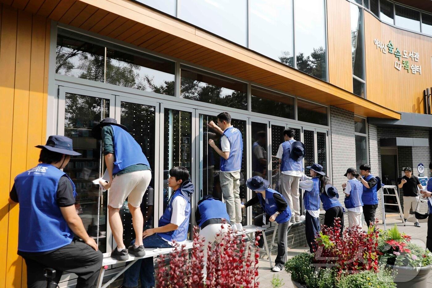 '구해조(鳥) kcc글라스' 캠페인 참여자들이 조류충돌방지스티커 부착 활동을 진행하고 있다. (KCC글라스 제공)