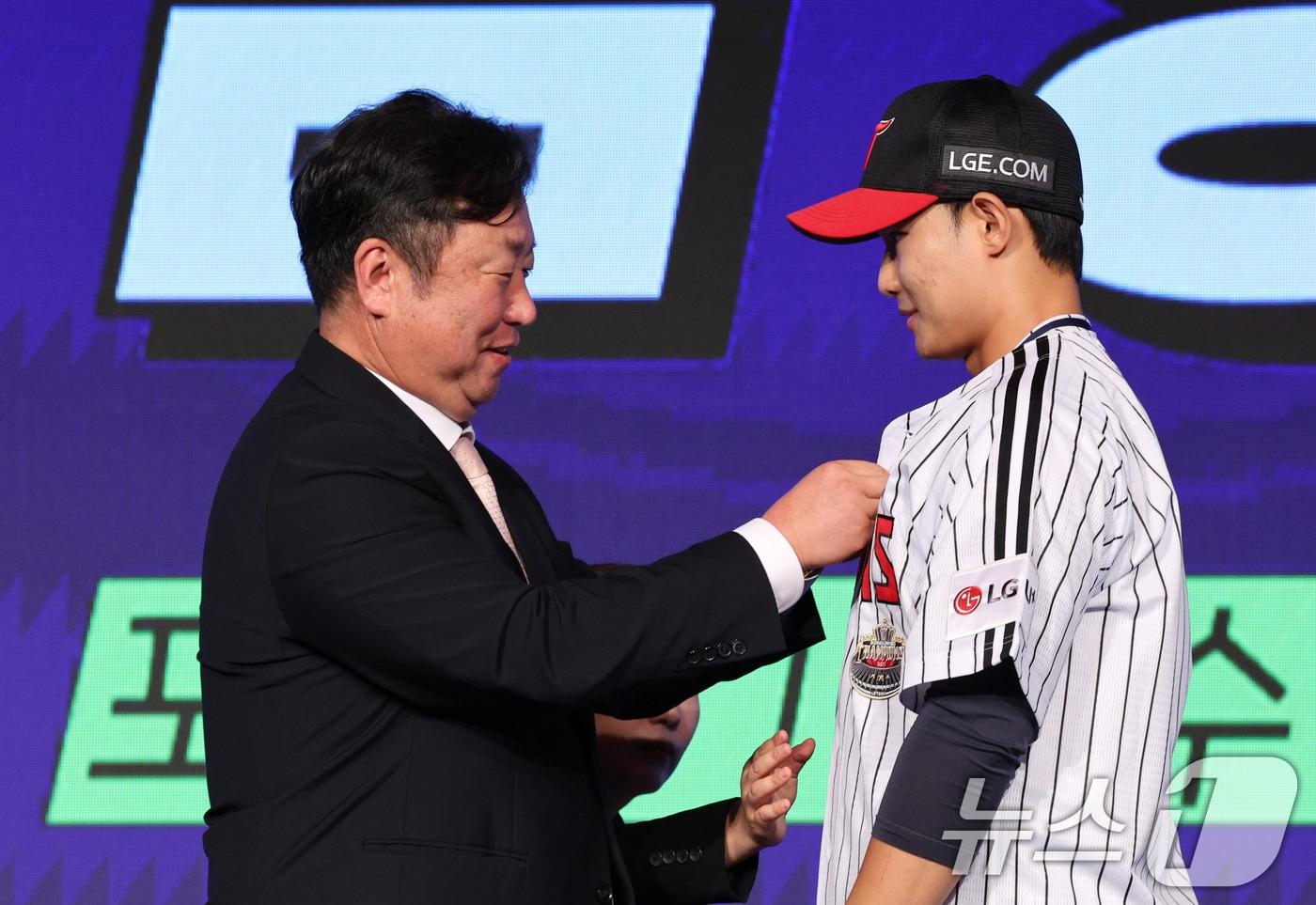 11일 오후 서울 송파구 롯데호텔 월드에서 열린 ‘2025 KBO 신인 드래프트’에서 LG 1라운드 10순위로 지명된 김영우(서울고)가 LG 차명석단장으로부터 유니폼을 받고 있다. 2024.9.11/뉴스1 ⓒ News1 장수영 기자