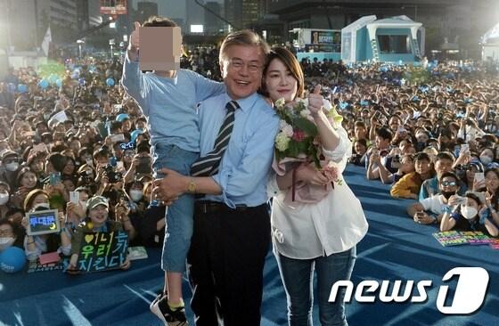 본문 이미지 -  2017년 5월 8일 서울 광화문 광장에서 열린 제19대 대통령 선거 마지막 유세에서 문재인 더불어민주당 대선후보가 딸 문다혜 씨와 손자로부터 카네이션을 선물받고 기념촬영을 하고 있다. 2017.5.8/뉴스1 ⓒ News1 허경 기자