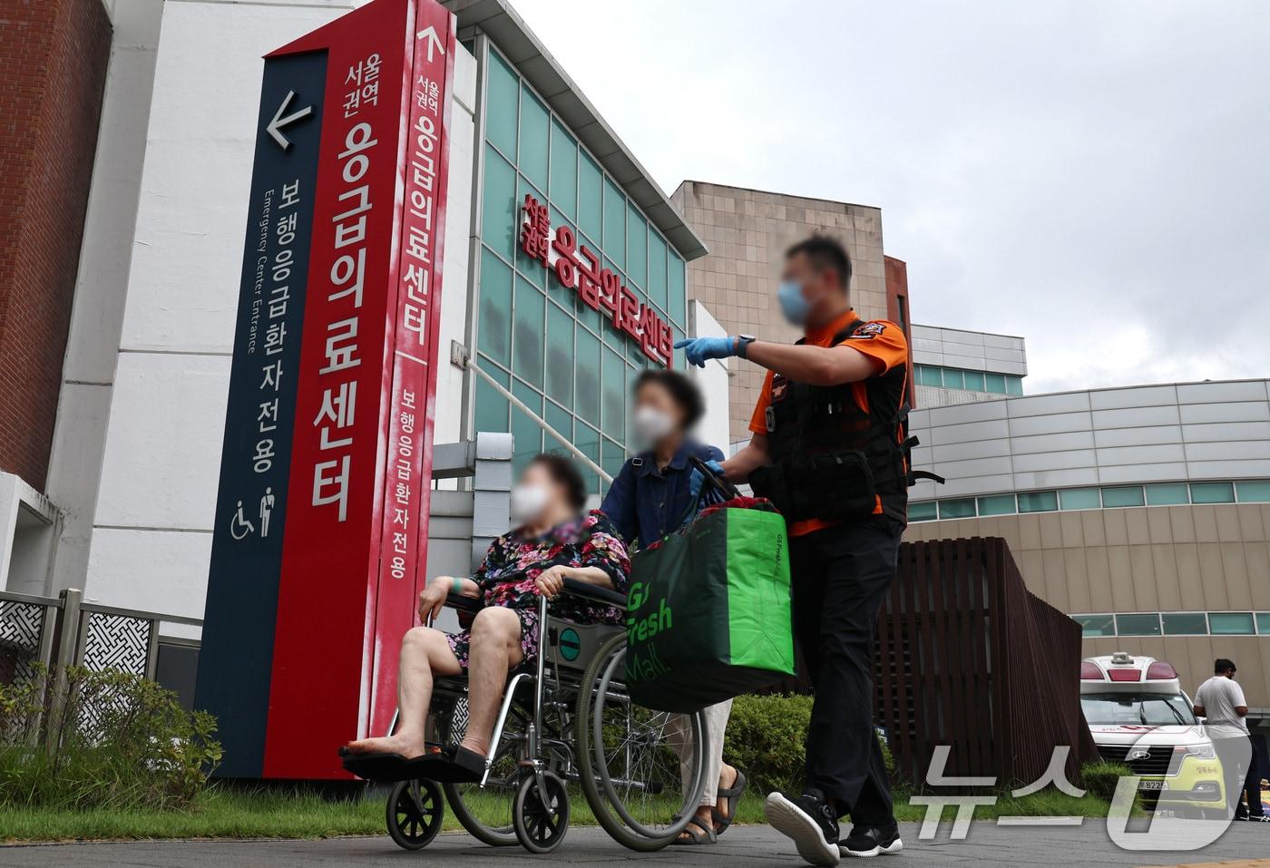 본문 이미지 - 추석 연휴를 앞둔 13일 오후 서울의 한 대형병원에서 구급대원이 응급환자와 보호자를 응급실로 안내하고 있다. 정부는 연휴에 응급실 환자가 몰리는 상황에 대비해 지난 11일부터 '추석 명절 비상 응급 대응 주간'을 운영하고 있다. 반면 의료계는 연휴 기간 중 '하루 최대 1만명' 정도가 제대로 된 응급 치료를 못 받을 가능성이 높다고 전망해 '명절 응급실 의료대란' 우려가 나타나고 있다./뉴스1 ⓒ News1 구윤성 기자