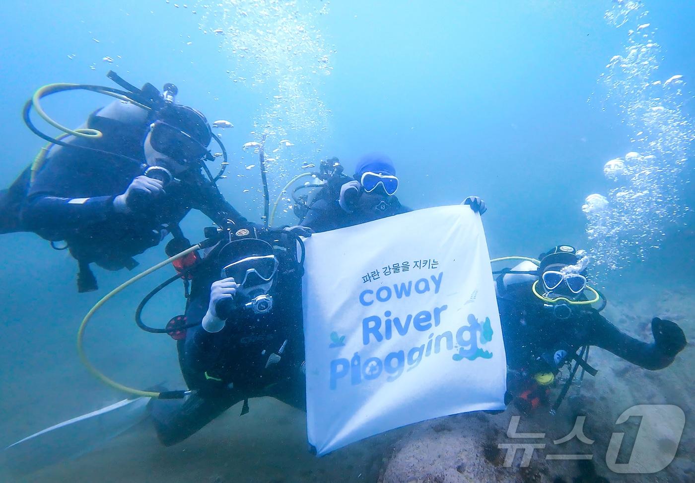 본문 이미지 - 코웨이 임직원 자원봉사단이 강원 고성군 송지호해변 바다에서 수중 쓰레기를 수거하고 있다.(코웨이 제공)