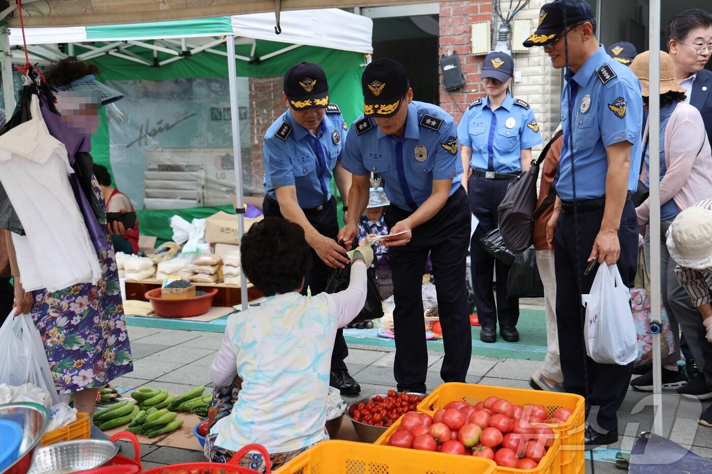 본문 이미지 - 추석 연휴를 앞둔 13일 김성종 동해지방해양경찰청장이 강원 동해시 북평민속시장을 방문해 먹거리를 구입하고 있다.(동해해경청 제공) 2024.9.13/뉴스1