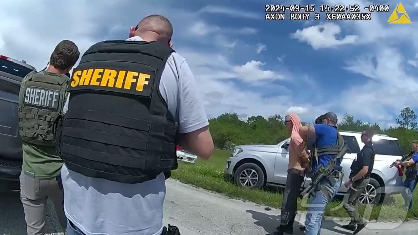 본문 이미지 - 16일(현지시간) 공개된 도널드 트럼프 전 대통령 암살 시도 용의자 라이언 웨슬라 라우스(58) 검거 순간.  분홍색 상의를 입은 자가 라우스다.<마틴 카운티 보안관실 페이스북 동영상 캡처>