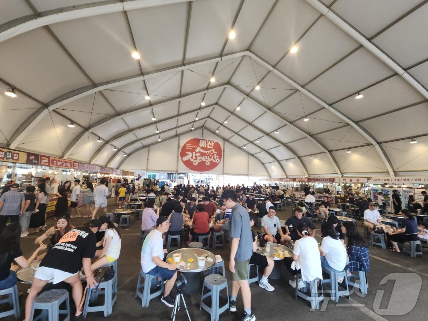 본문 이미지 - 16일 예산시장 방문객들이 임시 먹거리 광장에서 식사를 즐기고 있다. 식사 자리의 대기줄이 없이 듬성듬성 빈자리가 보인다. 2024.09.17 /뉴스1ⓒ 뉴스1 이찬선 기자.