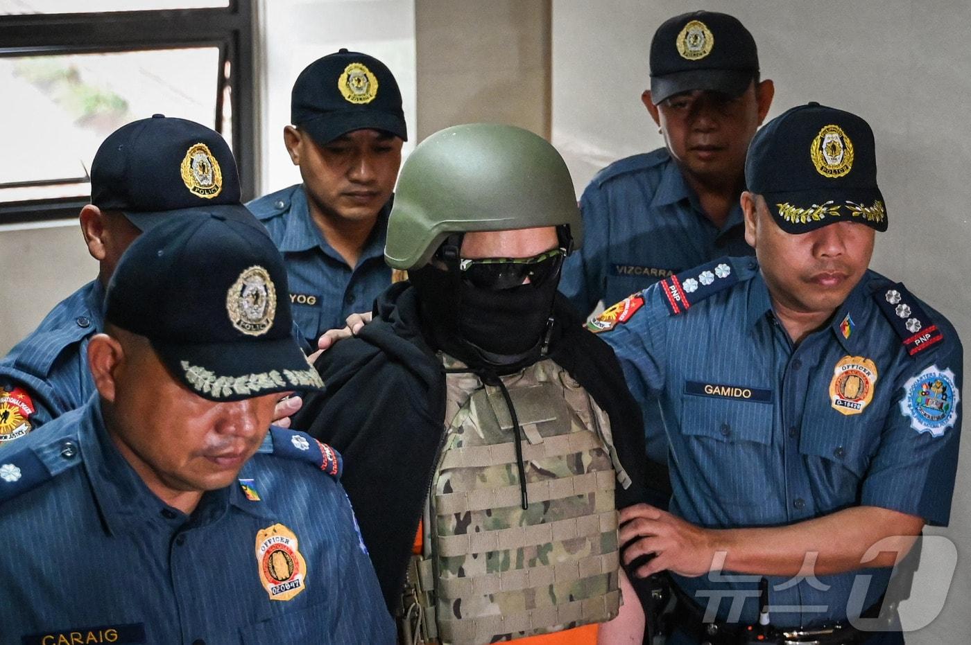 본문 이미지 - 13일(현지시간) 필리핀 마닐라의 한 법정에서 '예수 그리스도 왕국'(KOJC) 교회의 설립자인 아폴로 퀴볼로이(74)가 경찰에 연행되고 있다. 퀴볼로이는 수십 년간 필리핀과 미국에서 12~25세 여성 신도를 성착취한 혐의 등을 받아 체포됐다. 2024.09.13/ ⓒ AFP=뉴스1 ⓒ News1 박재하 기자