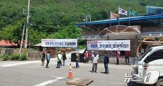 본문 이미지 -  지난 5월 영동군 양강면 산막리 신방동 마을 주민들이 공사 차량으로 안전사고 위험이 높다며 대책 마련을 요구하는 모습. (자료사진) /뉴스1