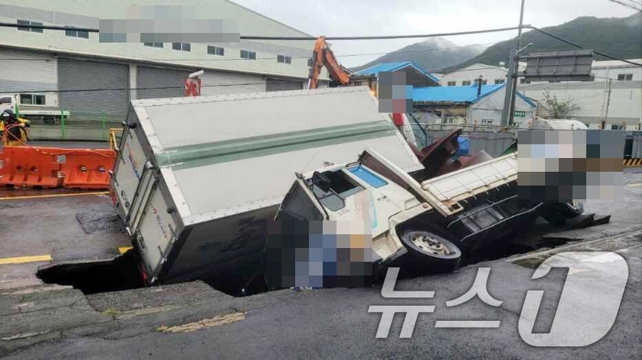 본문 이미지 - 21일 오전 부산 사상구 한 도로에서 가로 10m, 세로 5m, 깊이 8m 가량의 대형 땅꺼짐 현상(싱크홀)이 발생해 도로에서 배수 지원을 하던 삼락119안전센터 배수 차량과 5톤 트럭이 빠져있다. (부산경찰청 제공) 2024.9.21/뉴스1 ⓒ News1 윤일지 기자