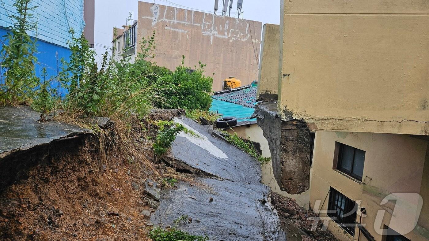 본문 이미지 - 21일 오후 부산 남구 대연동 건물 사이에 난 길이 무너져있다.(부산소방재난본부 제공)