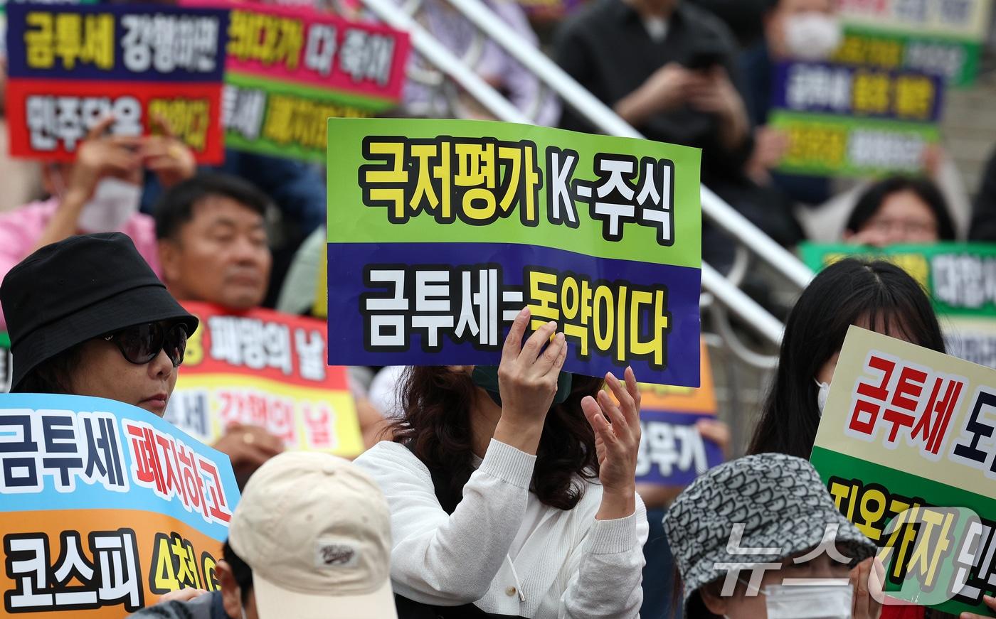 본문 이미지 - 한국주식투자자연합회 회원 및 개인투자자들이 21일 오후 서울 중구 서울역 광장에서 금융투자소득세 도입을 반대하는 피켓을 들어보이고 있다. 2024.9.21/뉴스1 ⓒ News1 장수영 기자