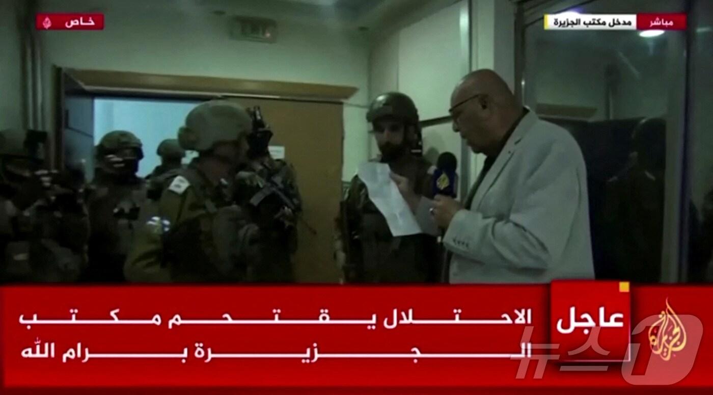 본문 이미지 - 22일(현지시간) 이스라엘군이 카타르 방송사 알자지라의 팔레스타인 요르단강 서안지구 지국을 급습해 45일간의 폐쇄를 명령했다. 사진은 급습 당시 송출된 알자지라 방송 화면. 2024.09.22/ ⓒ 로이터=뉴스1 ⓒ News1 박재하 기자