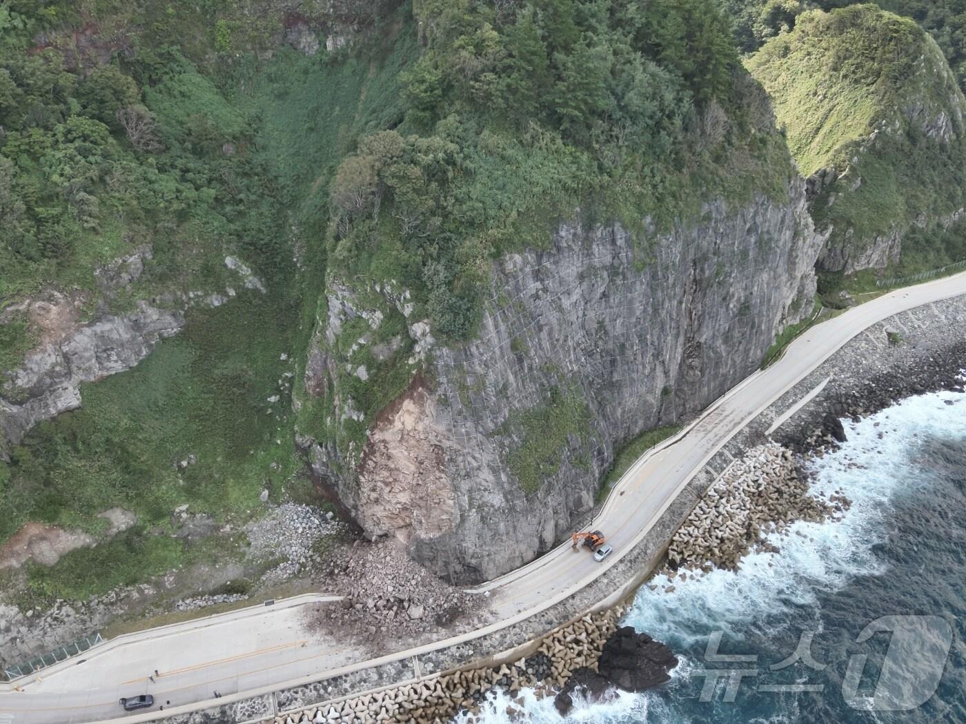 본문 이미지 - 경북 울릉군이 22일 오후에 밣생한 일주도로 죽암~ 선창 구간을 통제하고 복구작업에 나섰다. 울릉군이 중장비를 투입 낙석 제거작업을 서두르고 있다. (울릉군제공) 2024.9.23/뉴스1 
