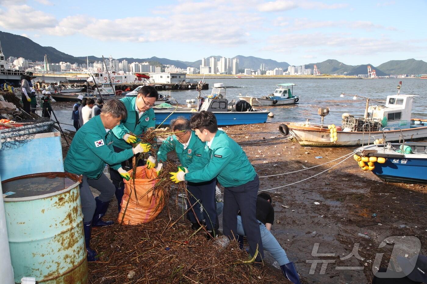 본문 이미지 - 홍남표 창원시장(왼쪽에서 두번째)이 23일 폭우로 밀려든 해양쓰레기를 수거하고 있다.(창원시 제공)