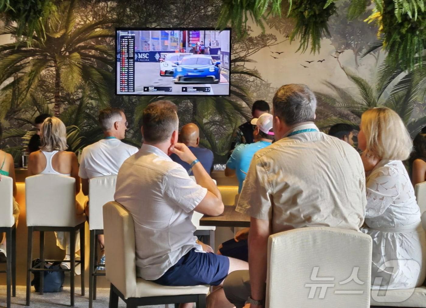 본문 이미지 - 지난 20~22일(현지 시각) 'F1 싱가포르 그랑프리'를 찾은 관람객들이 실내 라운지인 패독 클럽에 설치된 삼성전자 TV를 통해 실시간으로 경기를 관람하고 있는 모습.(삼성전자 제공)