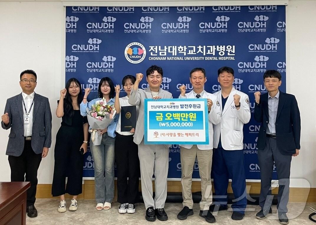 본문 이미지 - 봉사단체인 (사)사랑을 맺는 해피트리 김정주 대표(사진 왼쪽에서 다섯 번째)가 지난 12일 황윤찬 전남대치과병원장(사진 왼쪽에서 여섯 번째)에게 발전후원금 500만원을 전달하고 있다.(전남대병원 제공) 2024.9.24