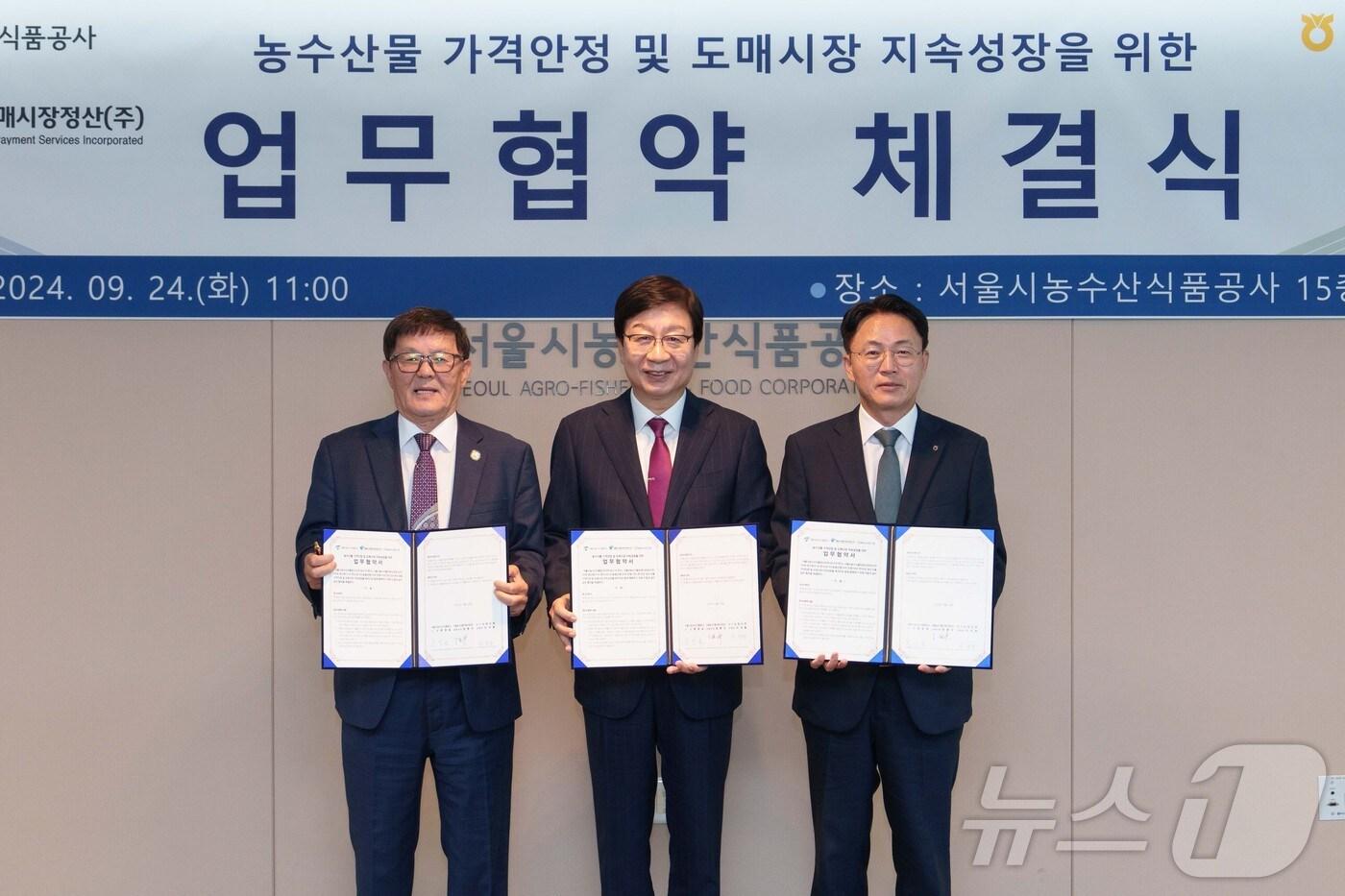 본문 이미지 - 24일 서울시농수산식품공사에서 열린 협약식에서 서울농수산물도매시장정산㈜ 정환수 공동대표(왼쪽부터) 문영표 서울농수산식품공사 사장, 이석용 농협은행 은행장이 기념촬영을 하고 있다.(농협은행 제공)