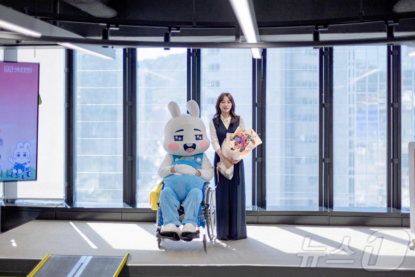 본문 이미지 - 휠체어 탄 다님이와 함께 포즈를 취하는 배우 천우희(서울관광재단 제공)