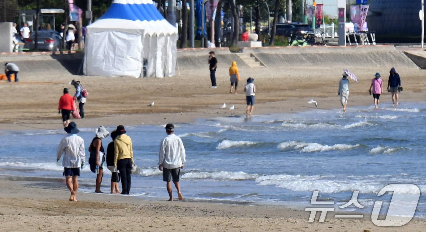 본문 이미지 - 25일 경북 포항시 북구 영일대해수욕장 백사장에서 아침 산책 나온 시민들이 맨발로 걸어가고 있다. 2024.9.25/뉴스1 ⓒ News1 최창호 기자