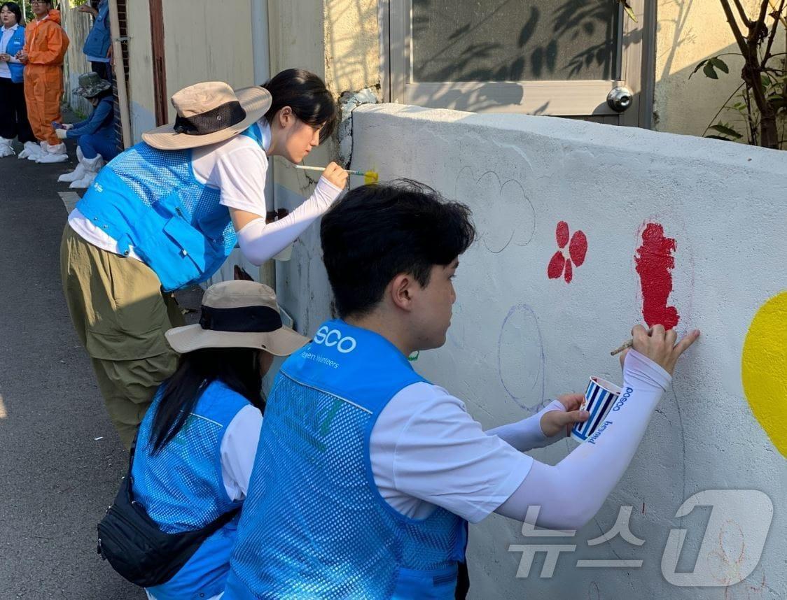 본문 이미지 - 포스코 비욘드봉사단이 광양 상봉마을에서 벽화 채색 봉사에 참여하는 모습(포스코 제공)