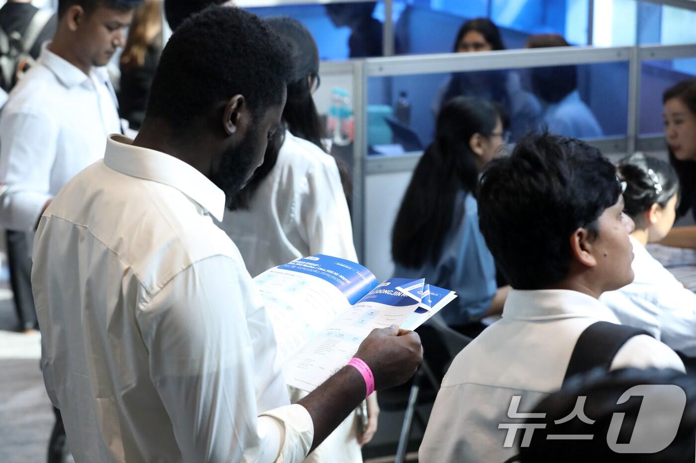본문 이미지 - '2024 부산 외국인 유학생 취업박람회'에서 외국인 유학생이 채용정보를 살펴보고 있다. /뉴스1 ⓒ News1 윤일지 기자
