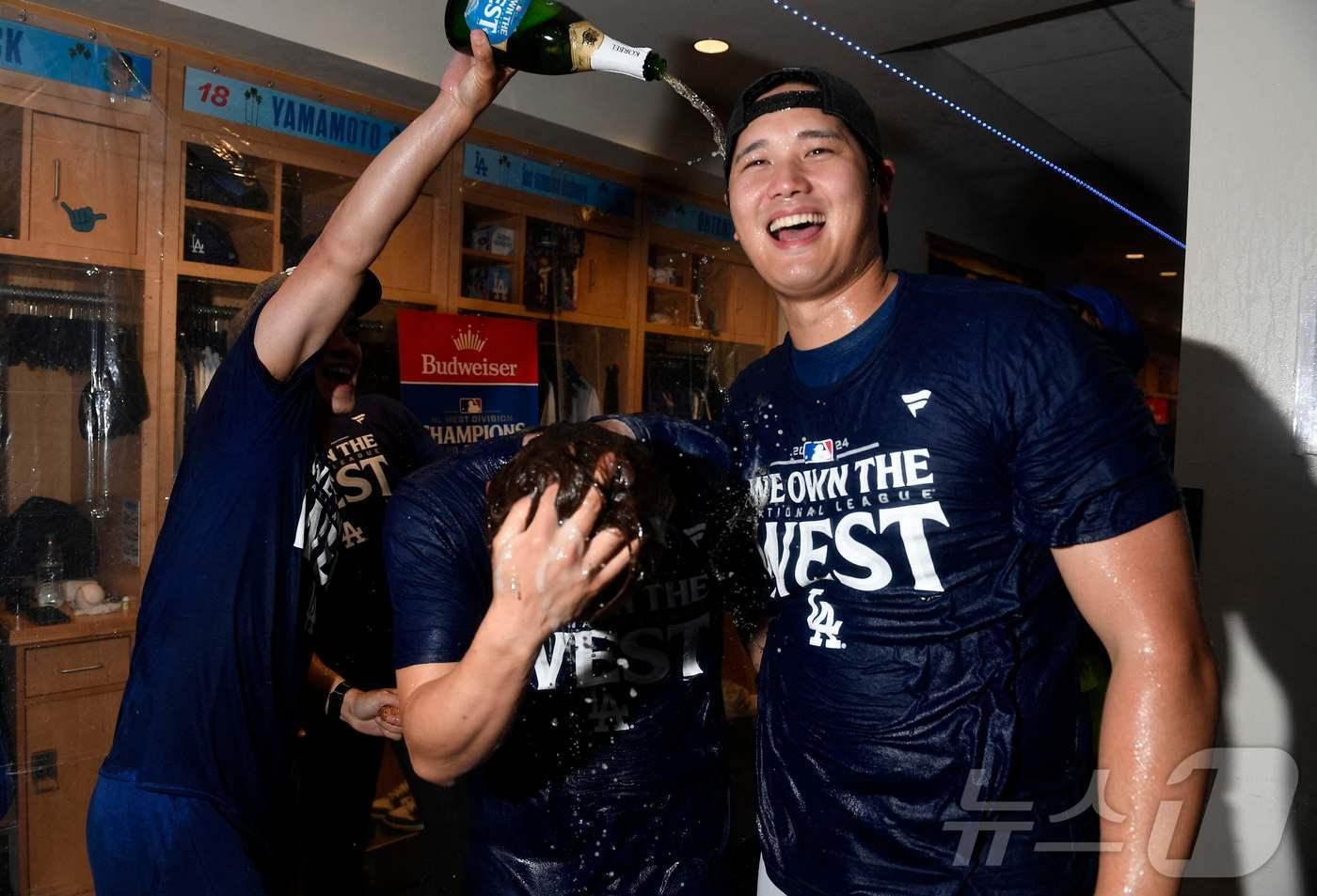 본문 이미지 - 오타니 쇼헤이(LA 다저스)가 27일(한국시간) 팀의 지구 우승을 확정지은 뒤 진행된 샴페인 파티에서 활짝 웃고 있다. ⓒ AFP=뉴스1