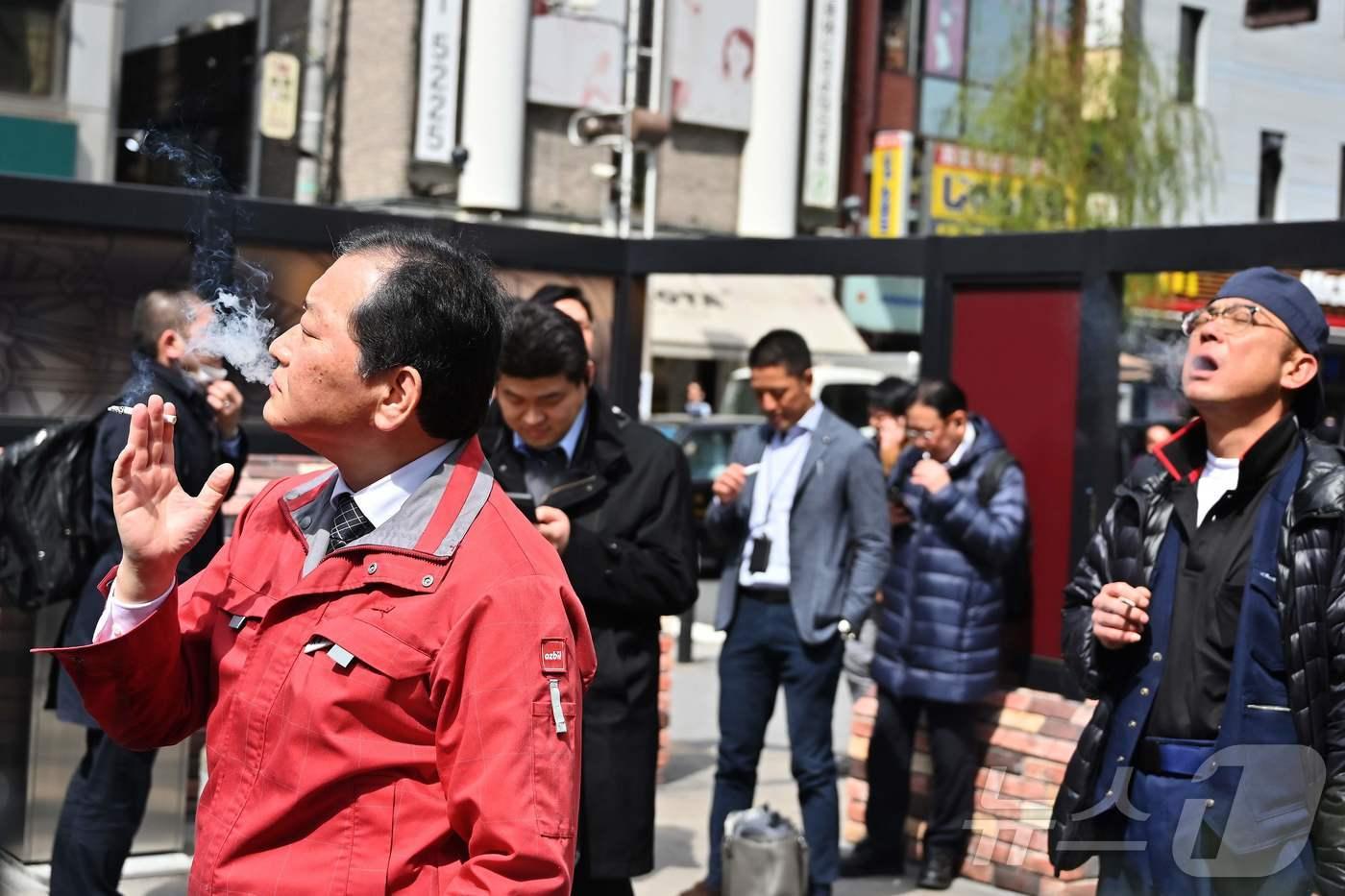 본문 이미지 - 일본 신바시 실외 흡연장에서 사람들이 담배를 피우고 있다. 2019.03.19/ ⓒ AFP=뉴스1 ⓒ News1 권진영 기자