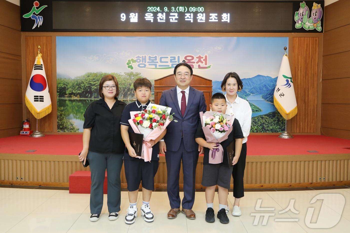 본문 이미지 - 황규철 옥천군수가 3일 직원조회에서 땅꺼짐 조기 신고를 통해 재난사고를 예방한 학생 2명에게 표창장을 수여하고 있다. 사진 왼쪽 옥천중 김민규, 오른쪽 죽향초 최시율 학생(옥천군 제공) /뉴스1