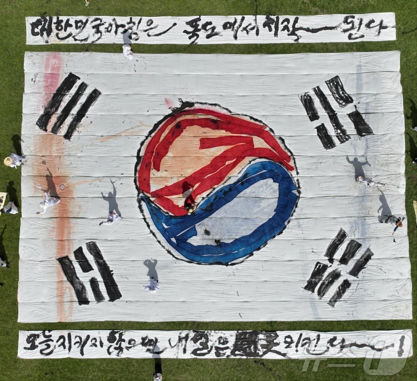 본문 이미지 - 서예작가인 김동욱 씨가 지난 29일 제3회 천연 염색문화축제가 열린 경주 엑스포공원에서 대형 태극기를 그려 독도 수호 의지를 다졌다. (사진작가 박상철 씨 제공) 2024.9.30/뉴스1
