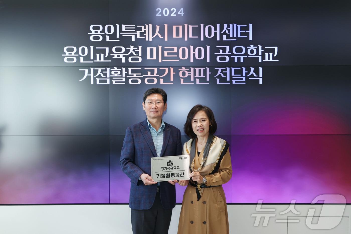 이상일 시장(왼쪽)이 30일 용인미디어센터에서 열린 용인미르아이 공유학교 거점 활동 공간 현판 전달식에서 김희정 용인교육지원청교육장과 기념촬영을 하고 있다.(용인시 제공)