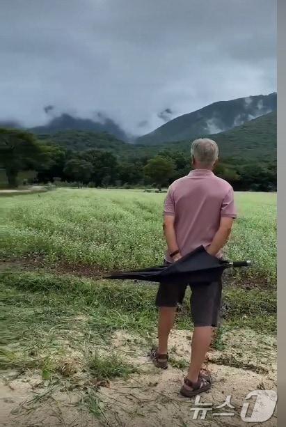 본문 이미지 -  문재인 전 대통령이 3일 경남 양산 통도사 부근 메밀밭으로 나와 먹구름이 잔뜩 끼고 바람 부는 하늘을 쳐다보고 있다. (SNS 갈무리) ⓒ 뉴스1