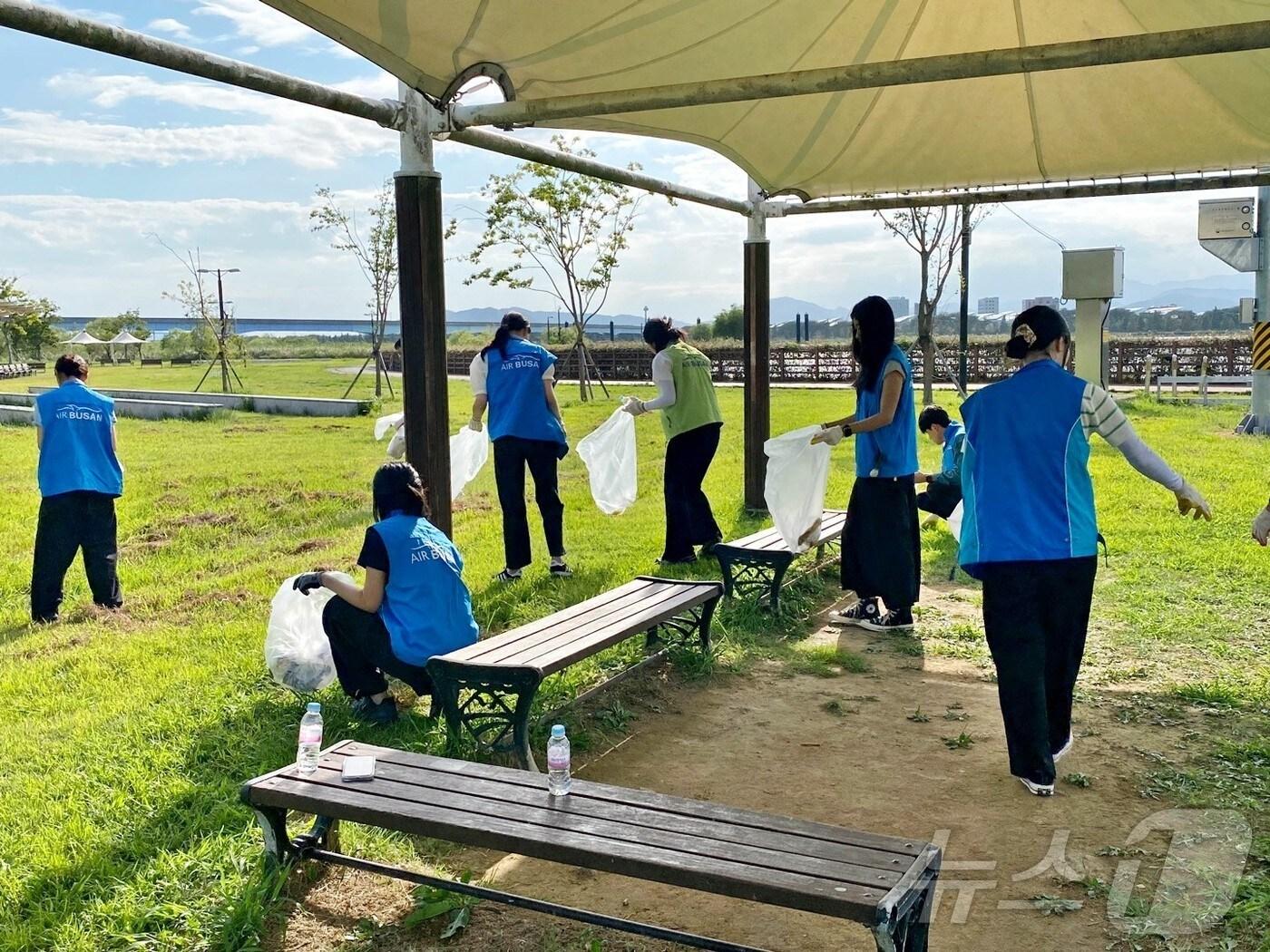 본문 이미지 - 지난 3일 에어부산 임직원들이 부산 삼락생태공원에서 환경정화 봉사활동을 실시하고 있다.(에어부산 제공)