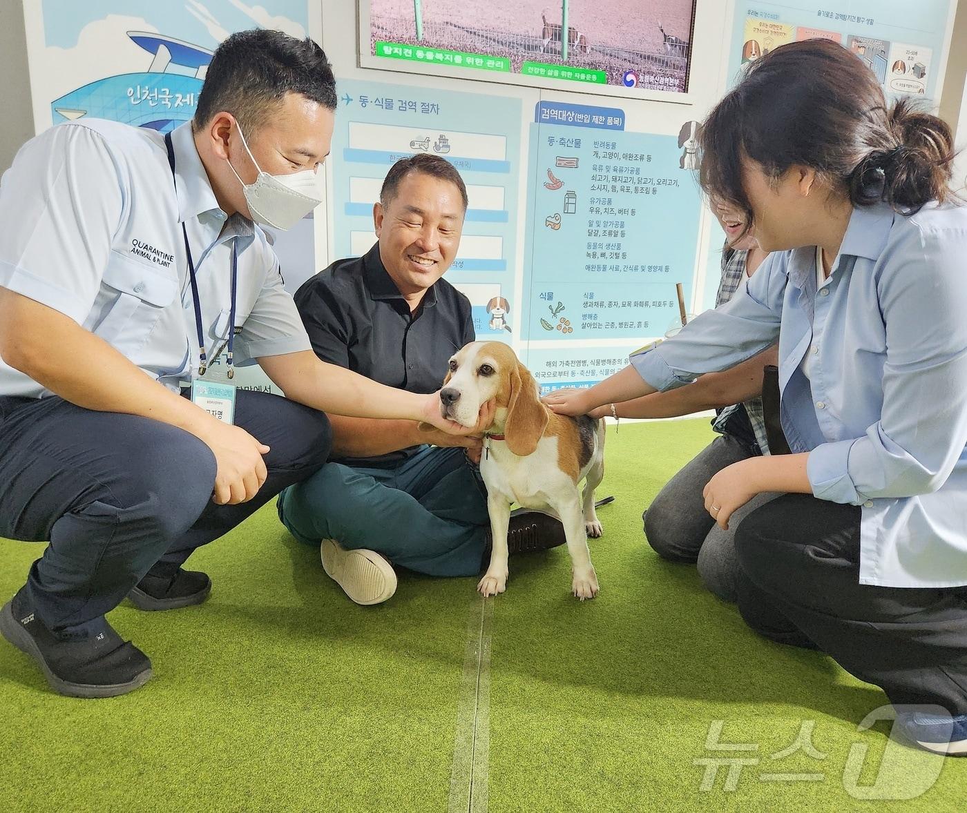 본문 이미지 - 서울 서초구 에이티(aT)센터에서 열린 2024 대한민국 농업박람회에서 은퇴 검역탐지견 '국화'가 구자명 농림축산검역본부 특수검역과 교관(왼쪽), 이웅종 케이씨엠씨(KCMC) 문화원 원장(왼쪽에서 두 번째)과 함께 관람객들과 교감하고 있다. ⓒ 뉴스1 한송아 기자