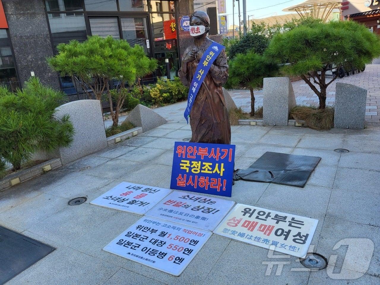 본문 이미지 - 4일 오전 창원시 마산합포구 오동동 문화광장에 설치된 일본군 위안부 소녀상에 혐오 문구가 적힌 손피켓 등이 놓여 있다.(독자 제공)