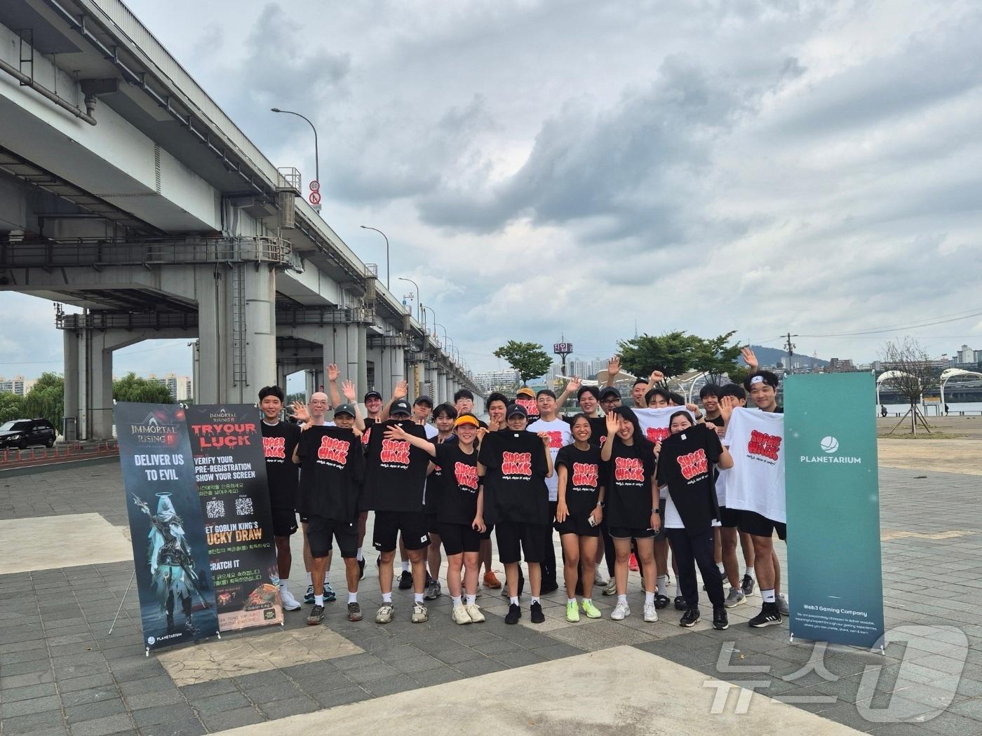 본문 이미지 - 슈퍼워크 팀원들이 행사 참가자들 중 일부와 2024년 9월5일 서울 서초구 반포한강공원에서 선라이즈 행사 기념 촬영을 하고 있다.