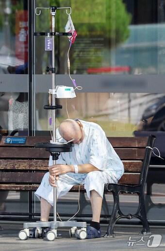 본문 이미지 - 서울에 있는 한 대학병원에서 환자가 수액걸이에 의지해 앉아있다./뉴스1 민경석 기자